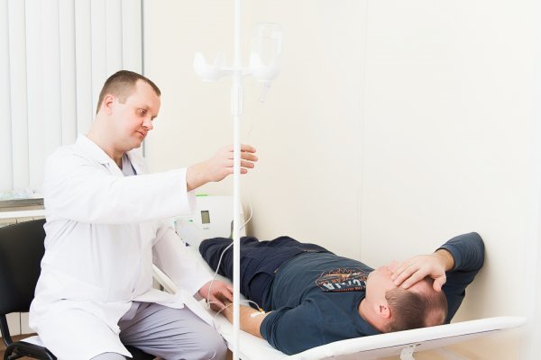 Врач ставит капельницу пациенту